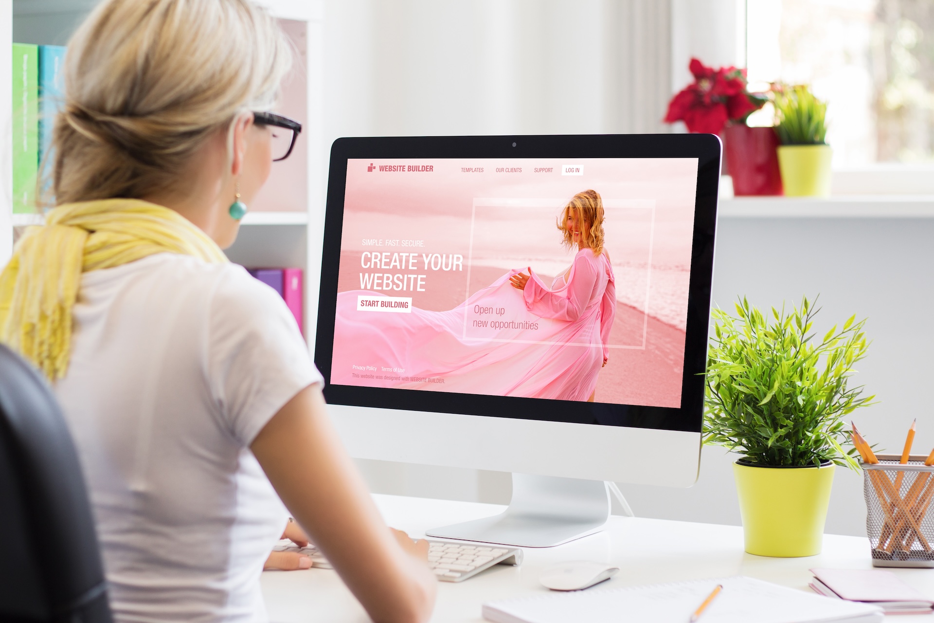 Eine Frau in einer WordPress Agentur arbeitet an einem Computer, auf dem ein Website-Builder geöffnet ist, um eine neue Website zu erstellen.