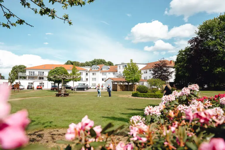 AuePark Seniorenzentrum in Preußisch Ströhen mit Gartenanlage, Bewohnern und Pflegefachkraft bei sonnigem Wetter