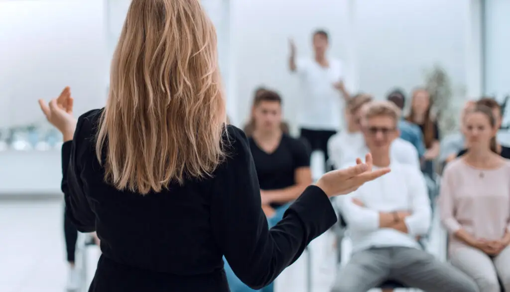 Trainerin erklärt Inhalte einer WordPress Schulung vor aufmerksamem Publikum in einem modernen Seminarraum