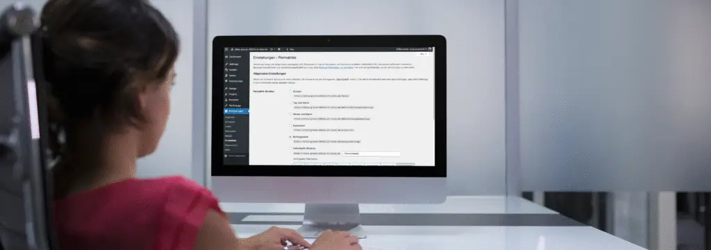 Frau arbeitet an WordPress Permalink-Einstellungen im Backend auf einem iMac